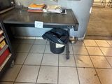a trash can sitting on a table in a kitchen