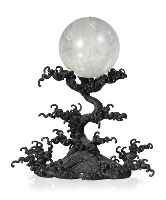 une sculpture en noir et blanc représentant un arbre surmonté d'une boule