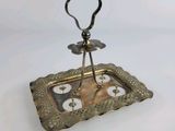 a silver plate with a heart shaped candle holder on it