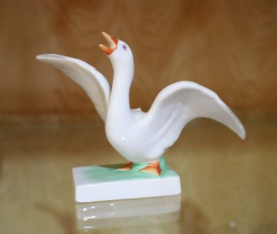 figurine en porcelaine représentant une oie blanche sur un socle vert