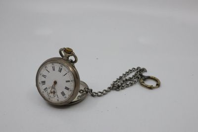 an old pocket watch with a chain hanging from it ' s side