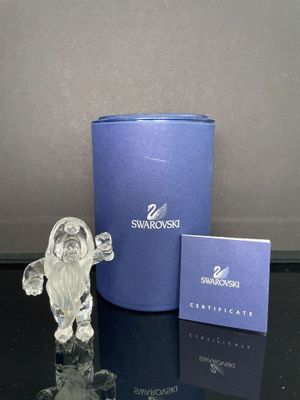 une figurine en verre posée à côté d'une boîte bleue