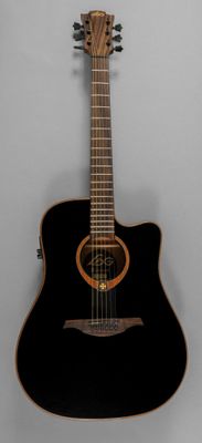 a black acoustic guitar hanging on the wall