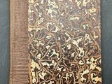an old book with a brown and black cover on a table