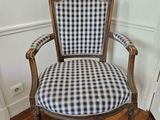 a blue and white checkered upholstered chair in the corner of a room