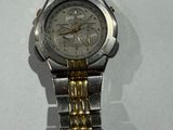 a silver and gold watch on a white surface