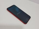 the back of a red and black cell phone sitting on a table