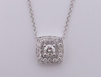 une photo d'un collier en diamants suspendu à une chaîne, posé sur un fond blanc