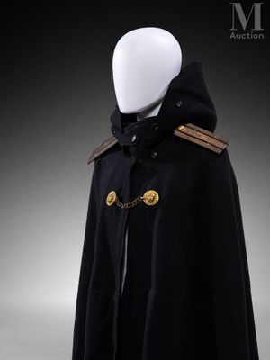 un mannequin blanc vêtu d'une cape noire ornée de boutons dorés