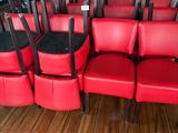 many red chairs in a row on a wooden floor