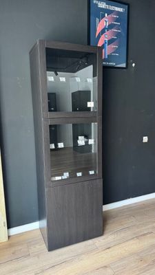 a tall cabinet in the corner of a room with a television on the wall
