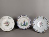 trois assiettes ornées de motifs, posées sur une surface grise