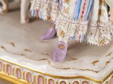 a figurine of a woman in a dress and purple shoes