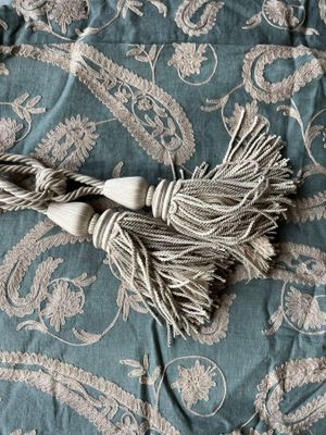 a close up of a blanket with a tassel on top of it