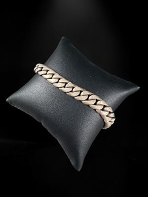 a close up of a silver bracelet on a black pillow