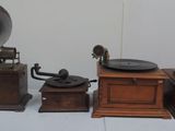 trois gramophones anciens exposés sur une table