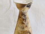 a small vase that is sitting on a white surface
