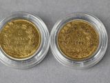 two pieces of gold coins, one of which is in a glass case