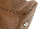 the back of a brown leather purse with a zipper on it
