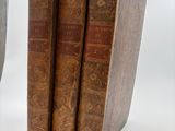 three old books sitting next to each other on a table