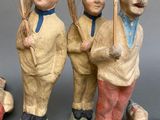 three figurines of a man and a woman with brooms