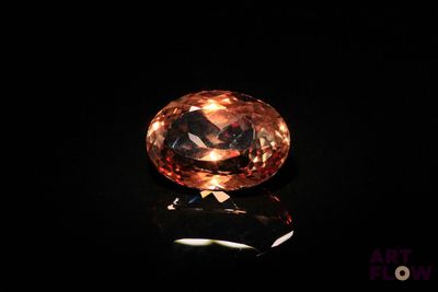 un diamant orange sur une surface noire