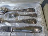 four silver spoons and a knife in a box