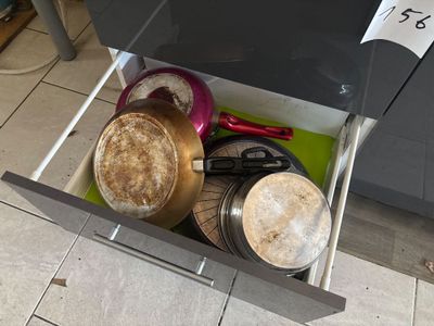 a drawer full of pots and pans in a kitchen