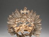 a gold plated headpiece with a bird and flowers on it