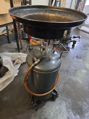 une grande casserole en métal posée sur une bonbonne de propane