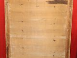 a piece of wood sitting on the floor in front of a red wall