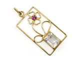 un gros plan d'un pendentif en or orné d'une pierre rose