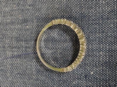 une photo d'une bague en or posée sur un tissu noir