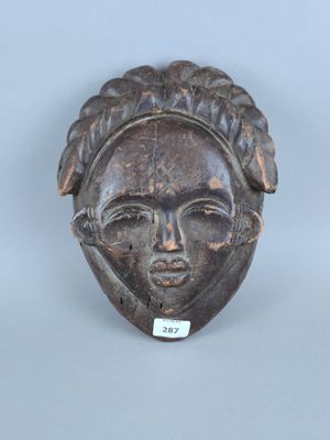 gros plan d'un masque en bois sur une surface blanche