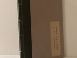 un livre posé sur une table, sur laquelle se trouve une feuille de papier