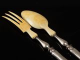 two forks and spoons are sitting next to each other on a black surface