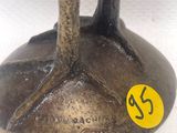 une statue en bronze représentant un oiseau, sur la tête duquel est collé un autocollant jaune