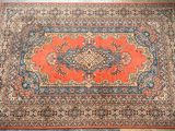 an orange and blue rug with a medallion design on it