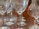 several empty wine glasses are lined up on a wooden table