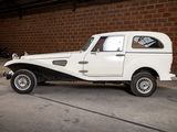 a white car parked in a garage with a brick wall in the background