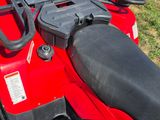 a close up of a red atv with a black seat