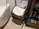 a white toilet sitting next to a trash can in a bathroom