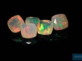 un gros plan sur un ensemble de pierres oplites posées sur une surface noire