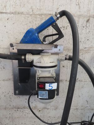 une pompe à essence fixée au mur, à côté d'un tuyau