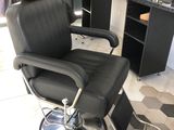 une chaise noire placée devant un miroir dans une pièce