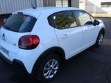 a small white car parked in a parking lot