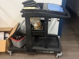 a black cart with a box on the floor next to it