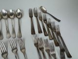 many forks and spoons laid out on the table