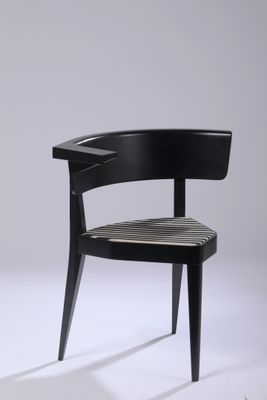 the chair is made of wood and has a black seat
