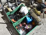 a green basket filled with assorted items sitting on the ground